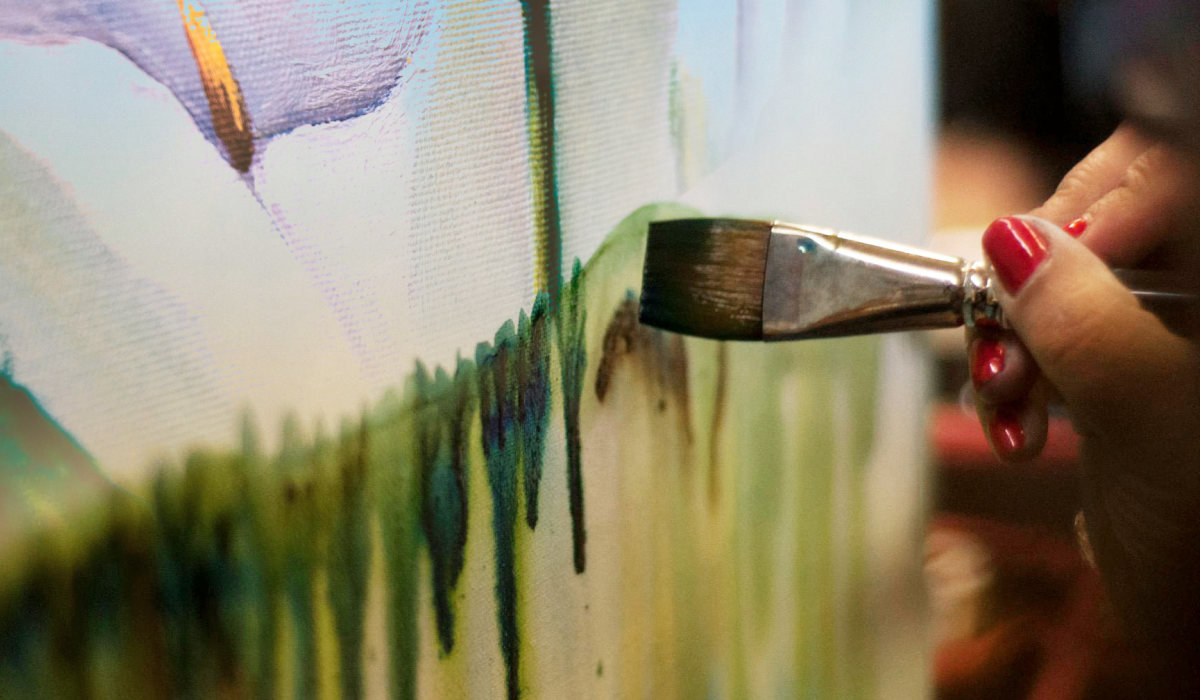 paint brush painting green paint on canvas